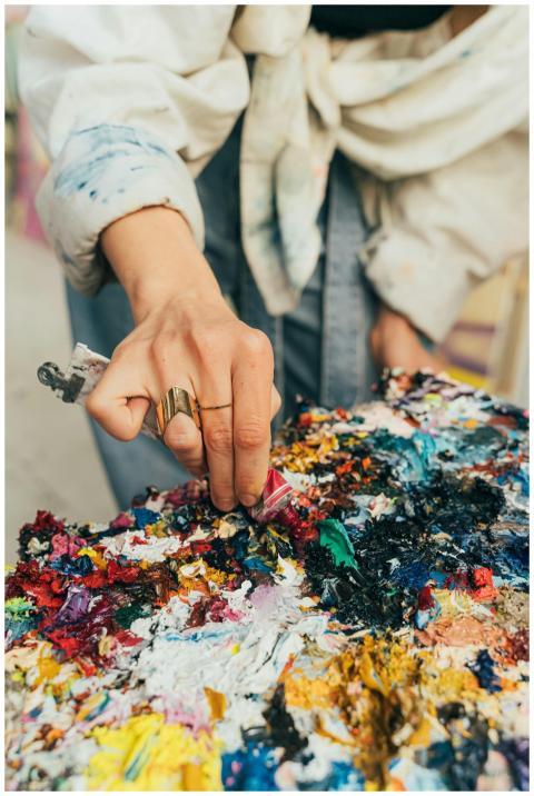 Close-up of an artist's hand mixing vibrant paints