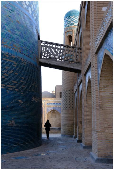 A solitary figure walks through historic Khiva, fr