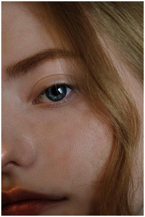 Intimate close-up of a woman's blue eye with blond