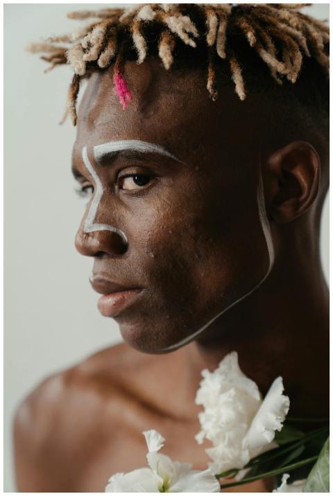 A conceptual portrait of a man with artistic makeu