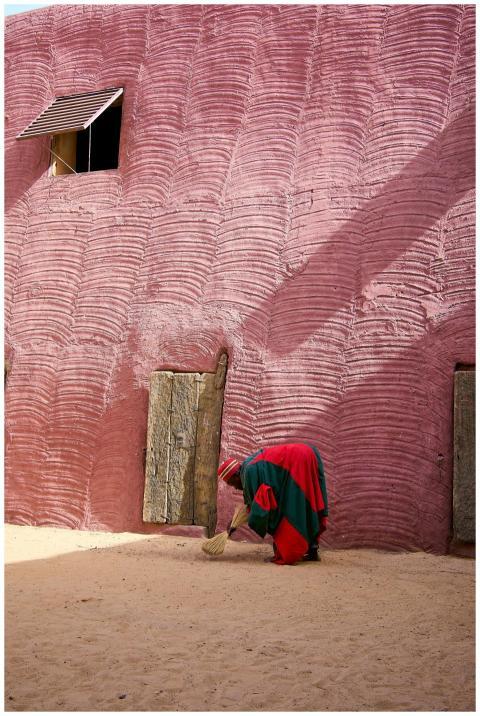 A person in traditional attire sweeps in front of