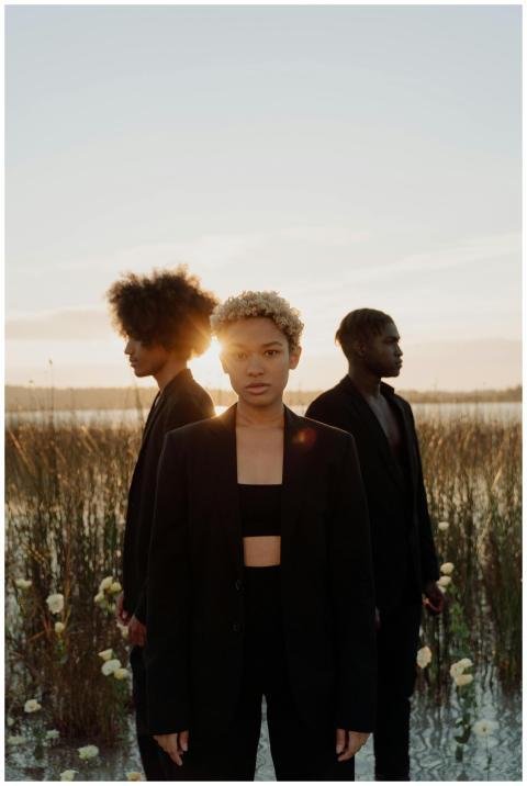 Artistic portrait of three people standing in shal