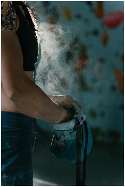 Close-up of a female climber applying chalk from a
