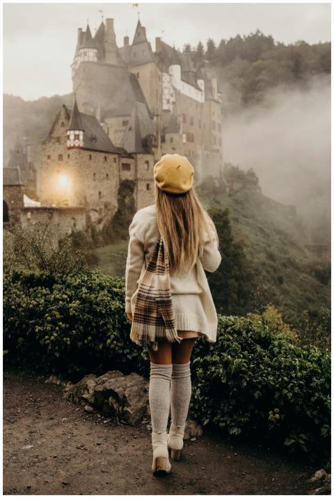 A woman in cozy autumn attire walks towards the mi