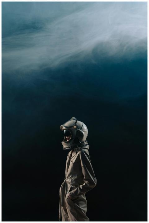 Person in astronaut suit and helmet against a clou