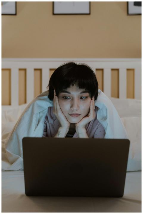 A woman comfortably browsing on her laptop while l
