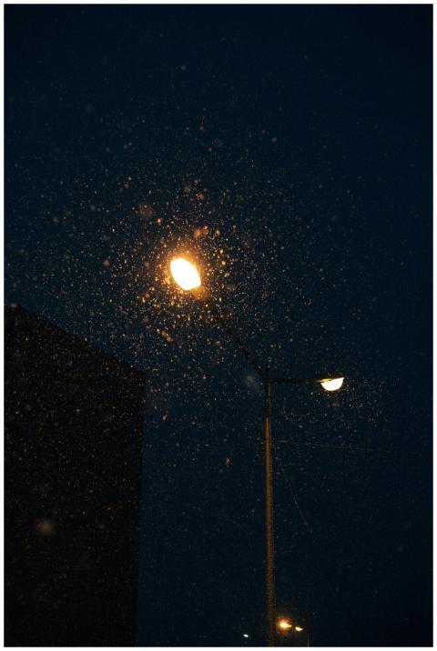Moody city night scene with street lamps lighting
