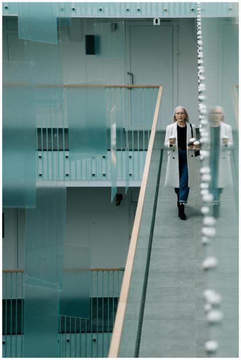 Woman walking in a sleek indoor office corridor wi