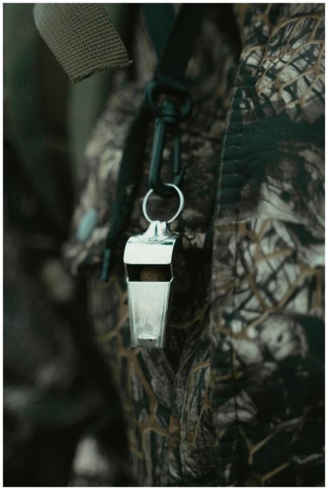 Close-up of a shiny silver whistle hanging against