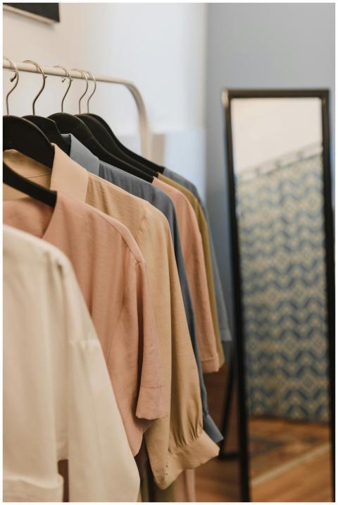 Fashion clothes displayed on hangers with a mirror