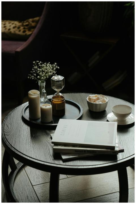 A cozy coffee table setting with books, candles, a