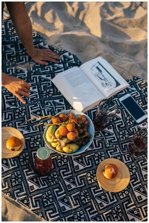 Enjoy a serene beach picnic with fresh fruits, dri