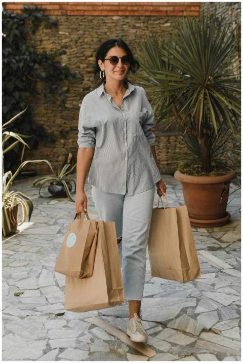 Fashionable woman smiles while carrying eco-friend