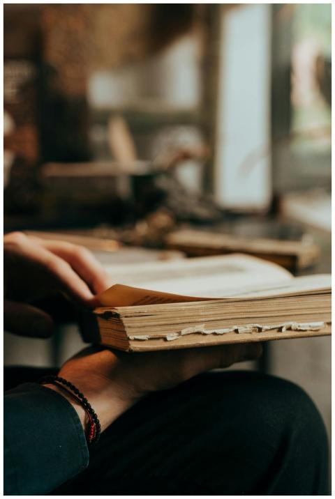 Close-up of hands holding an old book with a blurr