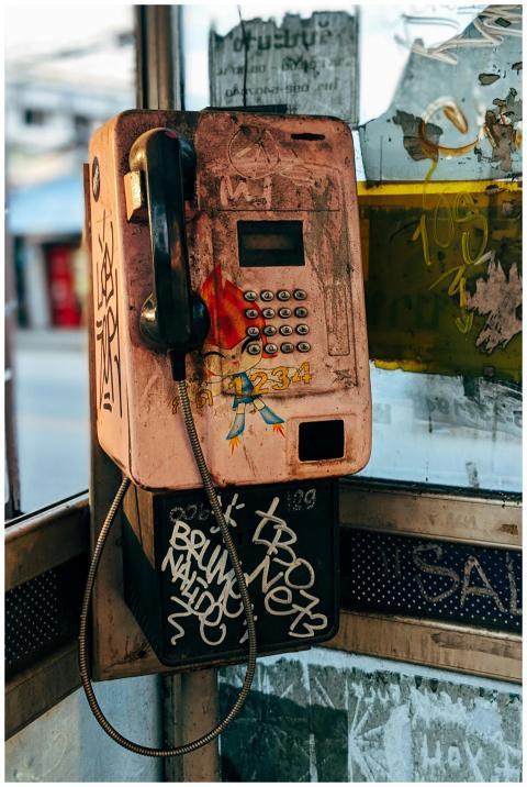 A retro phone booth with graffiti and urban decay