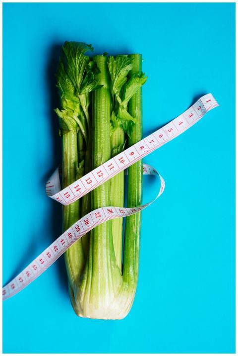 Vertical shot of fresh celery stalks wrapped in a