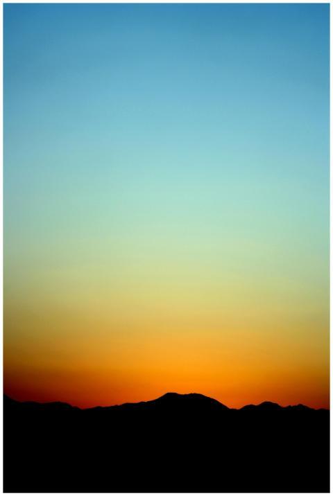 A stunning sunset creates a silhouette of distant