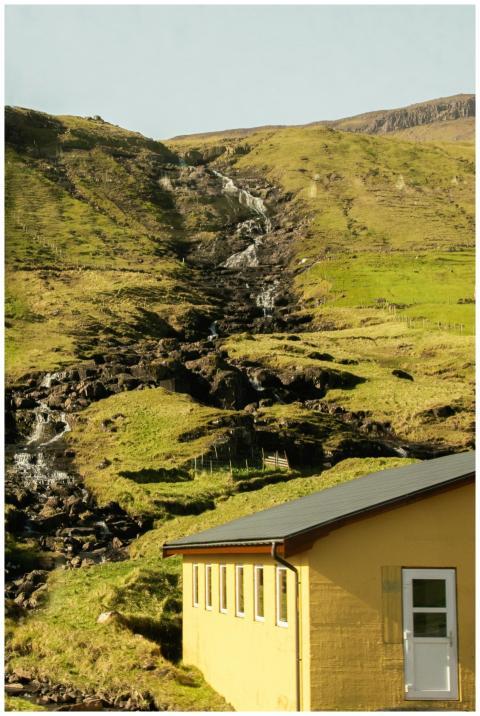 Serene hillside with cascading waterfall and a cha