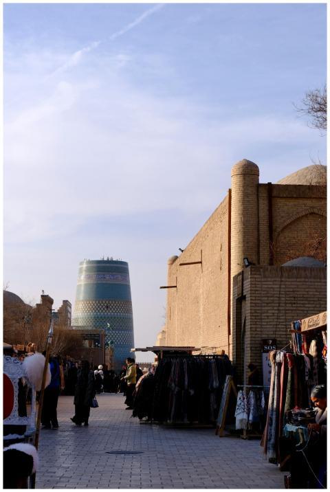 Bustling market street in Khiva with iconic Kalta