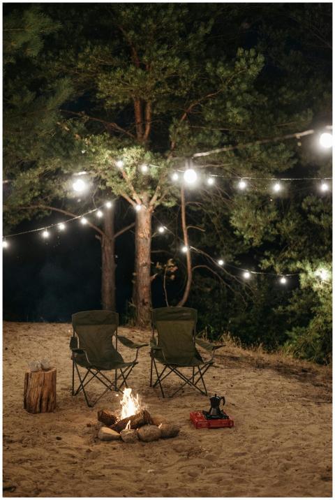 Peaceful campsite with bonfire, string lights, and