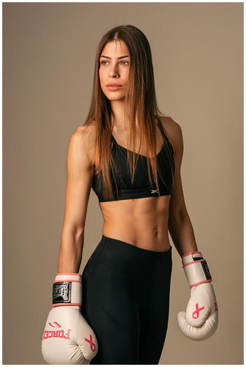 Portrait of a strong woman in boxing gloves in a s