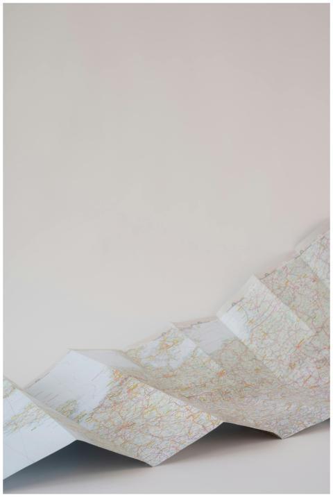 Folded paper map with intricate details on a plain