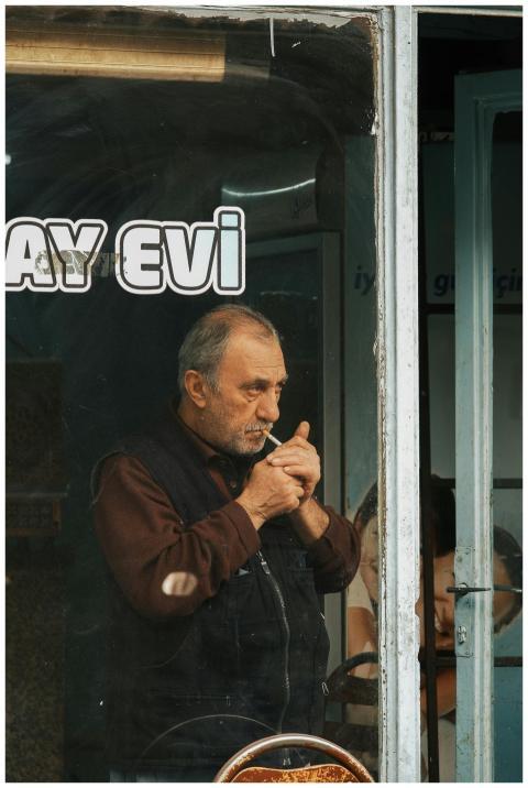 A man lights a cigarette inside a cozy, traditiona