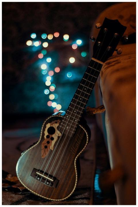 A wooden ukulele with bokeh lights, creating a coz