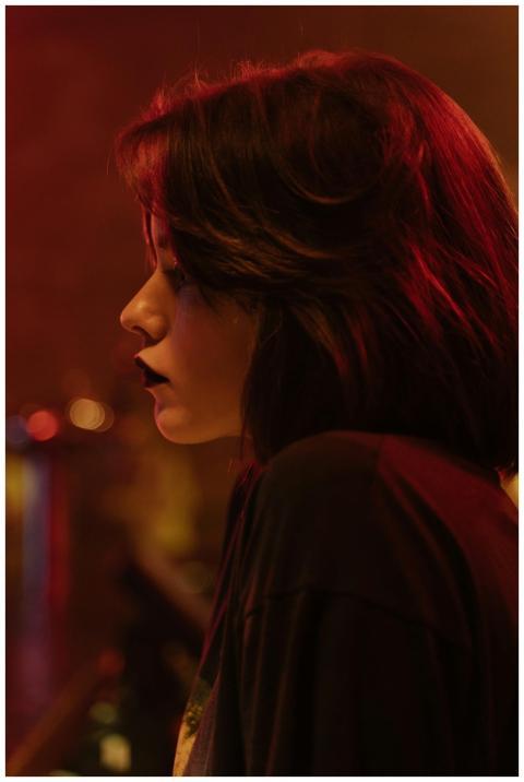 Side view of a brunette woman in a dim, moody sett