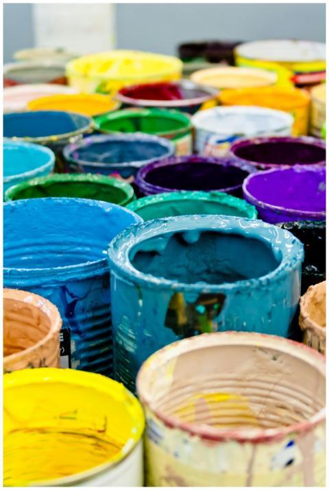 A vivid assortment of open paint cans displaying a