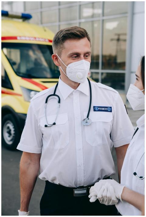 Paramedics wearing protective masks and gloves sta