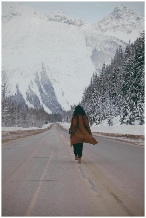 A person walks alone on a snow-covered road with m