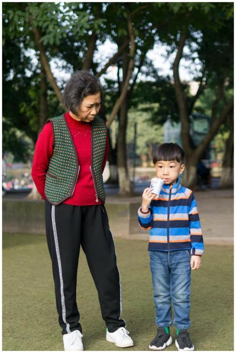 Elderly woman with her grandson in a park. The chi