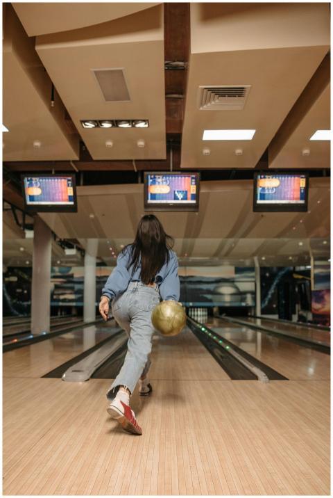 A woman engages in a lively bowling game at an ind