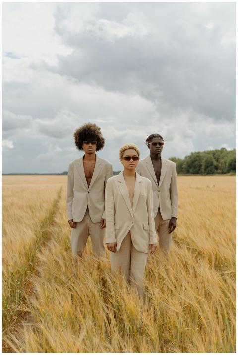 Three models in beige suits posing confidently in