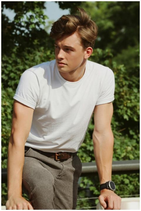 Fashionable young adult man posing confidently in