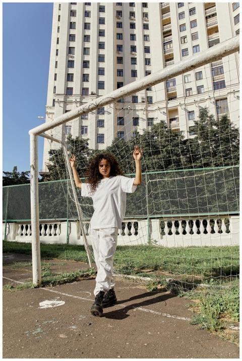 Woman in casual attire stands at a soccer goal in