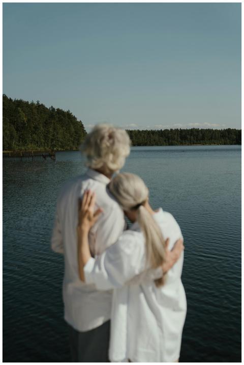 A senior couple shares a tender embrace beside a c