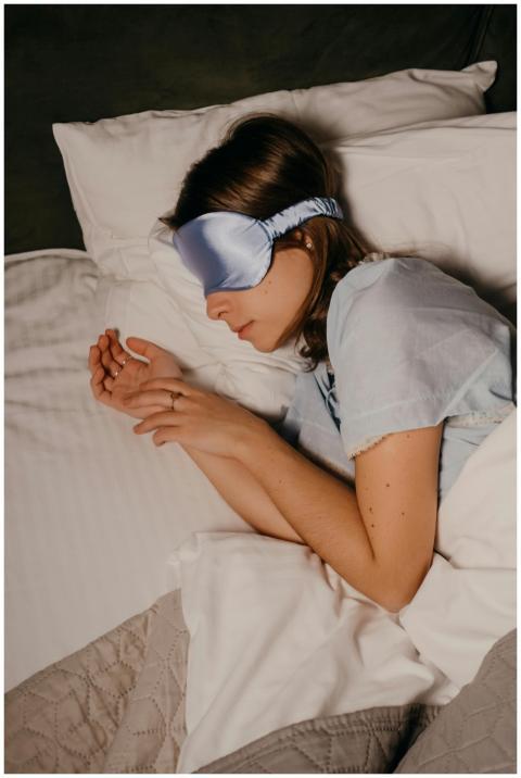 A woman sleeping peacefully with an eye mask in a