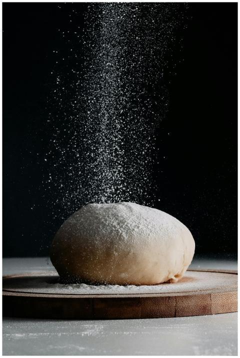 Captivating image of dough on a board as flour gra