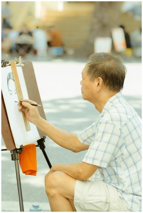An artist sketches a portrait on an easel in a sun