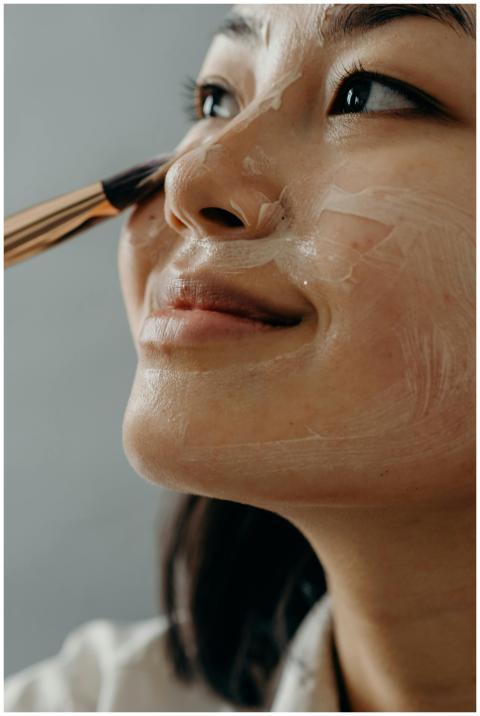Close-up of an Asian woman applying face cream wit