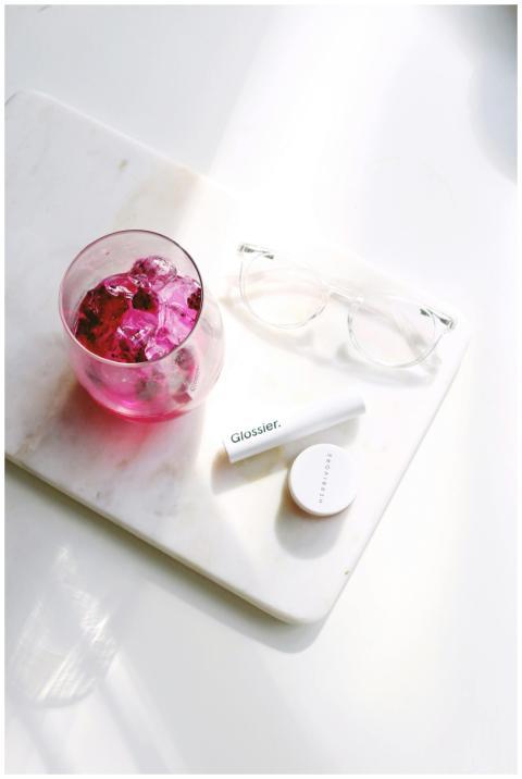 Flat lay of cosmetics with pink drink on marble, p