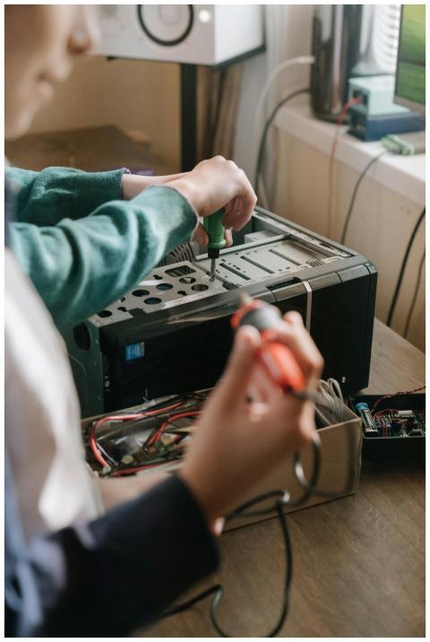 Adults working together to repair a computer using