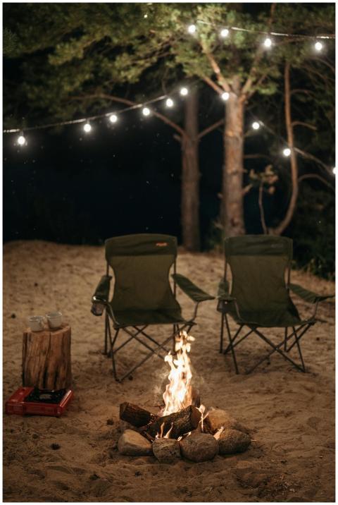 A cozy night scene featuring two chairs by a campf