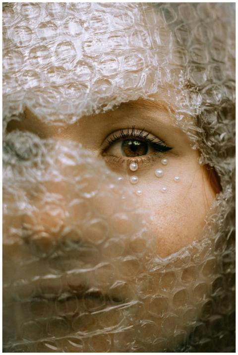 Close-up artistic portrait of a woman covered in b