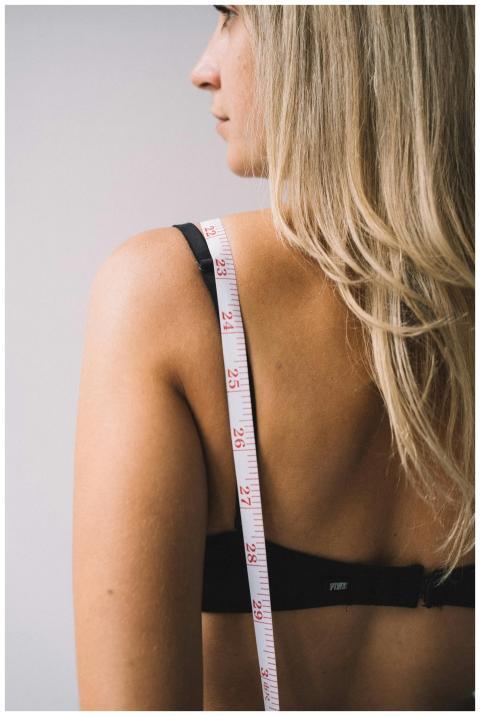 Side view of a blonde woman with a tape measure dr