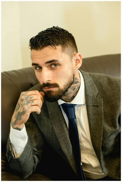 Elegant portrait of a bearded man with tattoos wea