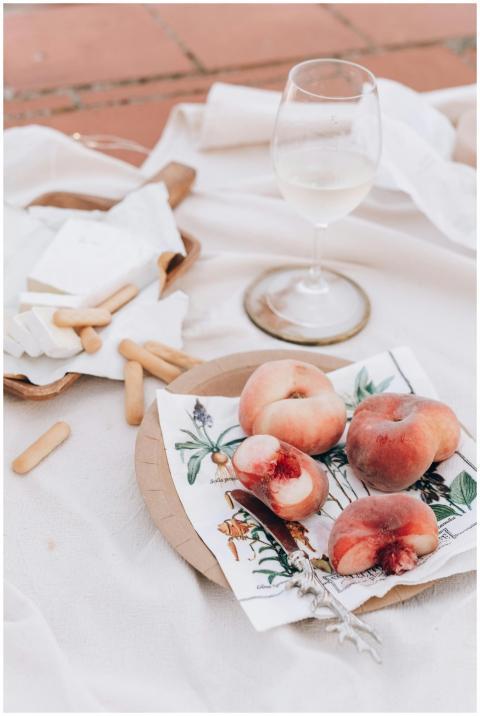 A stylish rooftop picnic featuring fresh peaches,