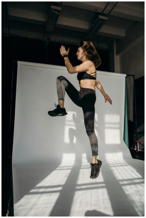 Dynamic shot of a woman in activewear jumping in a